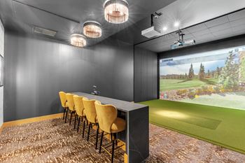 A room with a long table and chairs with a screen at the end of the table.